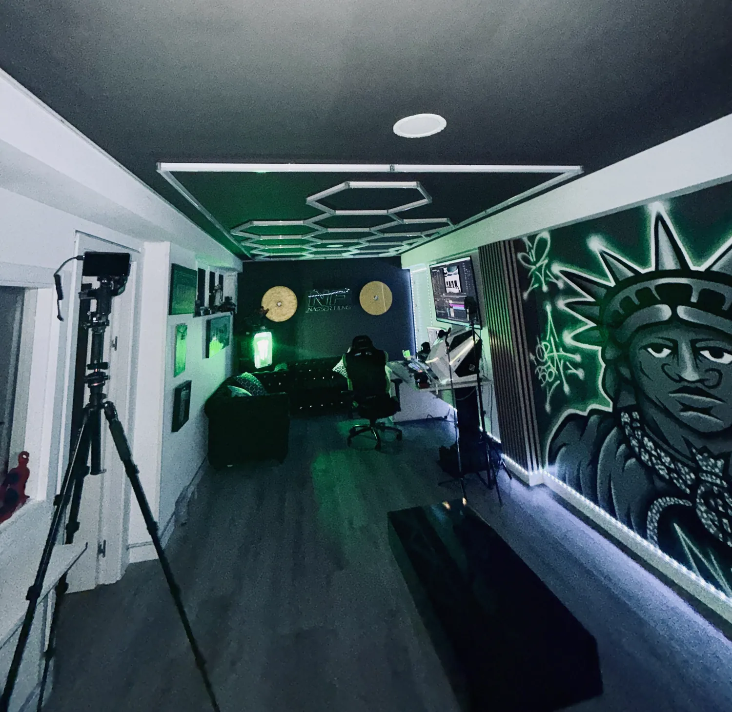 El estudio de NASSER FILMS con luz verde, el mural de la Libertad y el neón NF